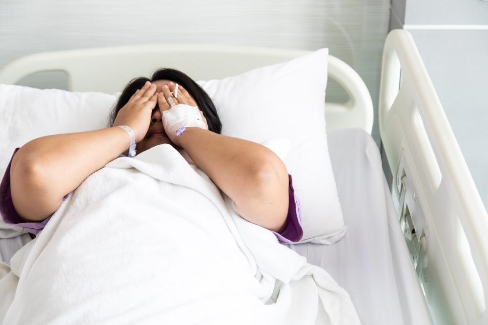 Asian fat woman patient feeling sad and depressed lying at hospital bed